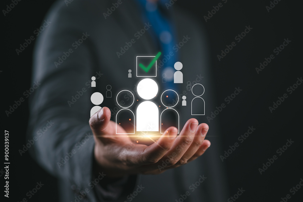 Human Resources Recruitment and Hiring Concept. Businessman holds virtual icons representing potential candidates, with one icon highlighted and a check mark, illustrating HR recruitment and hiring. Human Resources Recruitment and Hiring Concept. Businessman holds virtual icons representing potential candidates, with one icon highlighted and a check mark, illustrating HR recruitment and hiring.