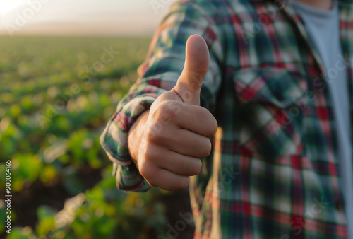 a farmer giving a thumbs up gesture on a farm field background