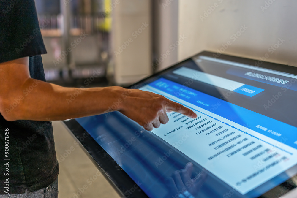 Obraz premium Engaging with Technology: A User Interacting with a Touch Screen Display