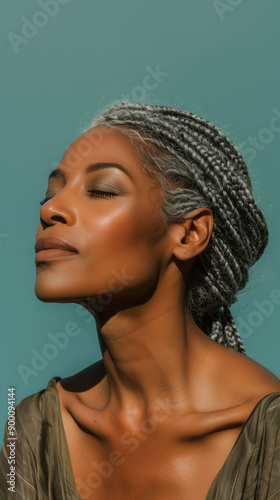 profile of middle aged black woman with braided hair, braids, cornrows, box braids, long braids, hairstyles, blue green background, hairdo, gray hair, greying hair, blue green aqua background photo