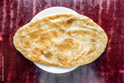 Fried Paratha or parata served in plate isolated on table background top view of bangladeshi, indian and pakistani food photo