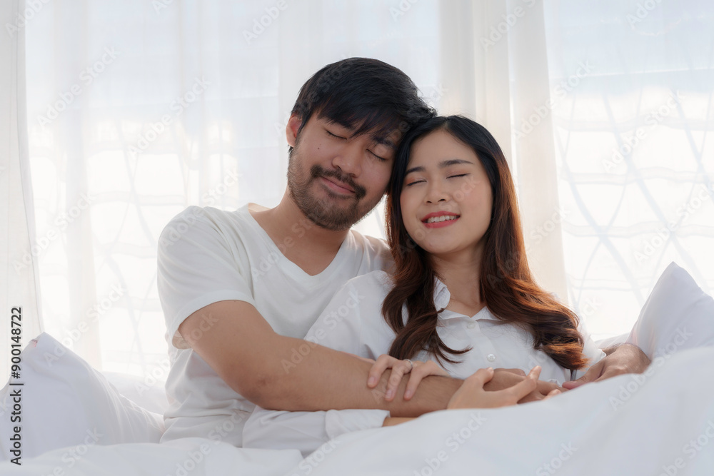 Young asian couple is sharing a tender moment while lying in bed with their eyes closed Young asian couple is sharing a tender moment while lying in bed with their eyes closed