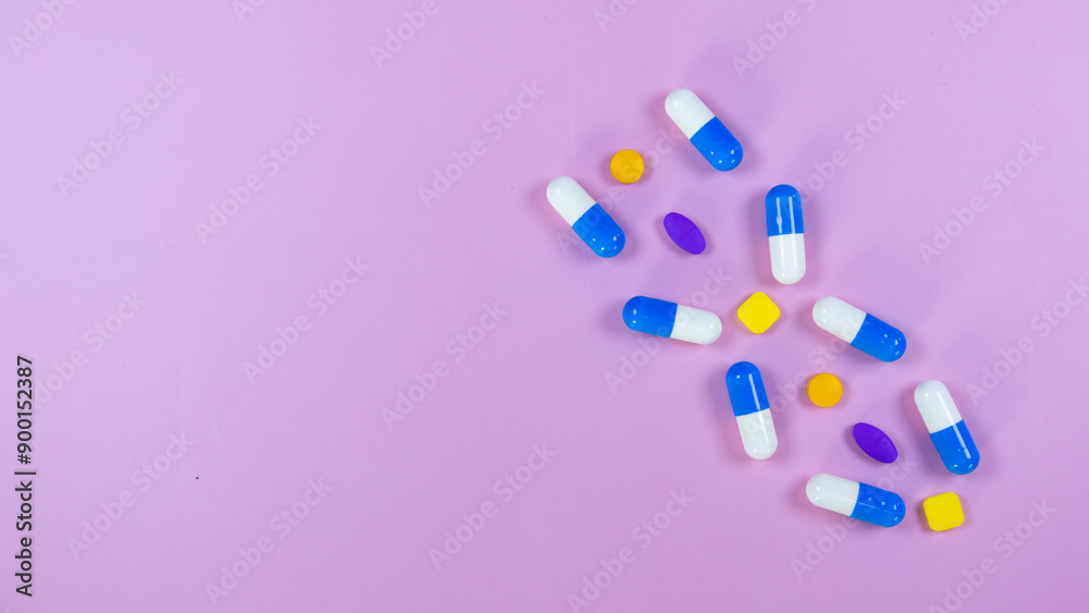 Multi-colored pills, capsules used in medical treatment are arranged in a gene pattern on a pink background. Healthcare and medical concept. concept of genetic illness. Space for text. Multi-colored pills, capsules used in medical treatment are arranged in a gene pattern on a pink background. Healthcare and medical concept. concept of genetic illness. Space for text.