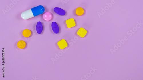 Assorted pharmatheutical multicolored medicinal capsules, pills used in medical treatment on pink background . Colorful pills and capsules. Healthcare and medical concept. Space for text.