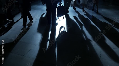 Wallpaper Mural Silhouetted pedestrians casting shadows on city street at night, creating mysterious atmosphere Torontodigital.ca
