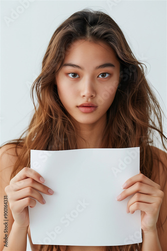 A Korean cosmetic model holding a whiteboard, face, sleeveless dress, very bright white background studio