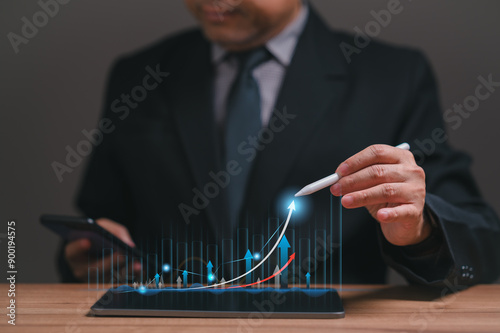фотографія A businessman in a suit uses a tablet to examine a marketing graph, utilizing technology to analyze financial charts and plan investments, driving business growth and ensuring success