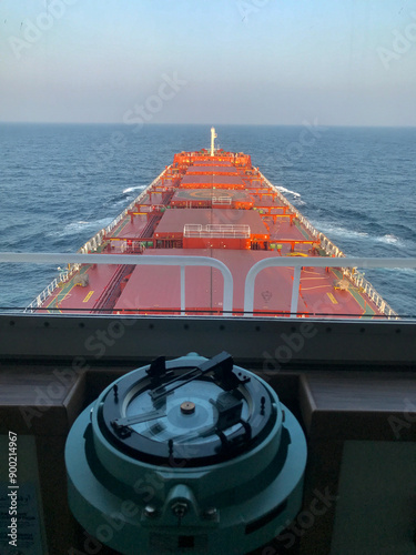A merchant ship underway at sea with gyro compass in the foreground