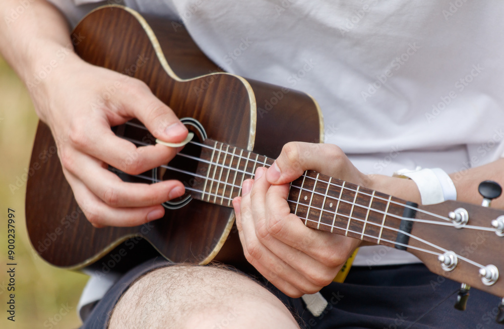 Fototapeta premium Men play the guitar. Hands close up
