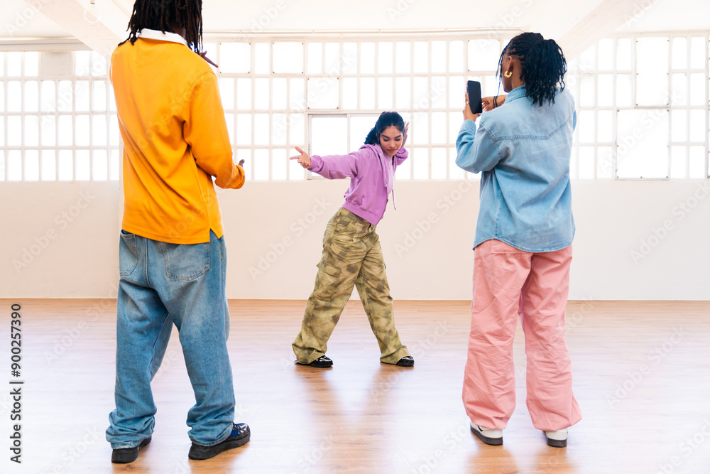 Fototapeta premium YYoung group of multiethnic hip-hop dancers wearing colorful urban streetwear dancing - Stylish multiracial rap crew portrait in indoors dancing studio