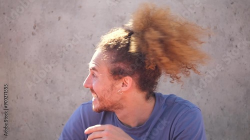 Latin redhead man with a beard and a ponytail surprised and excited about good news
