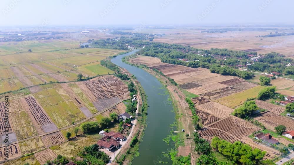 Aerial view from top of long natural green river with plantation and village house Aerial view from top of long natural green river with plantation and village house