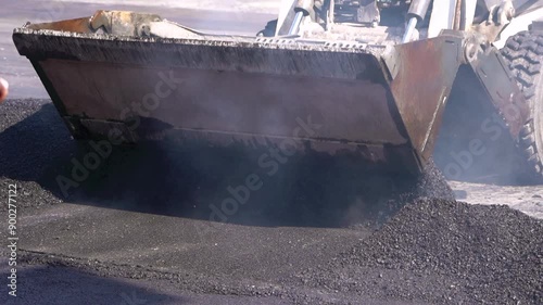 Closeup of heavy machinery paving asphalt, illustrating industrial road construction in progress for road development