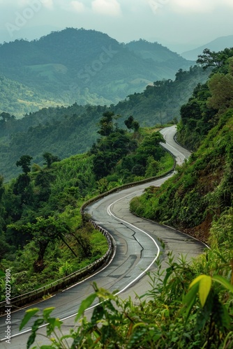 A picturesque winding road surrounded by mountains, suitable for travel or outdoor adventure © Fotograf