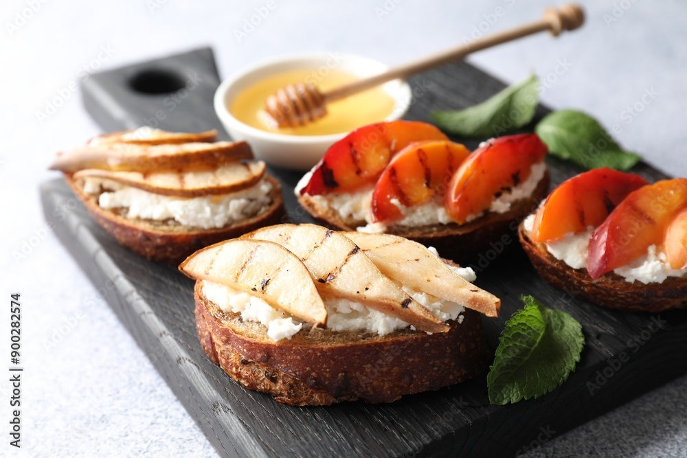 Delicious bruschettas with ricotta cheese and honey on light grey table, closeup Delicious bruschettas with ricotta cheese and honey on light grey table, closeup