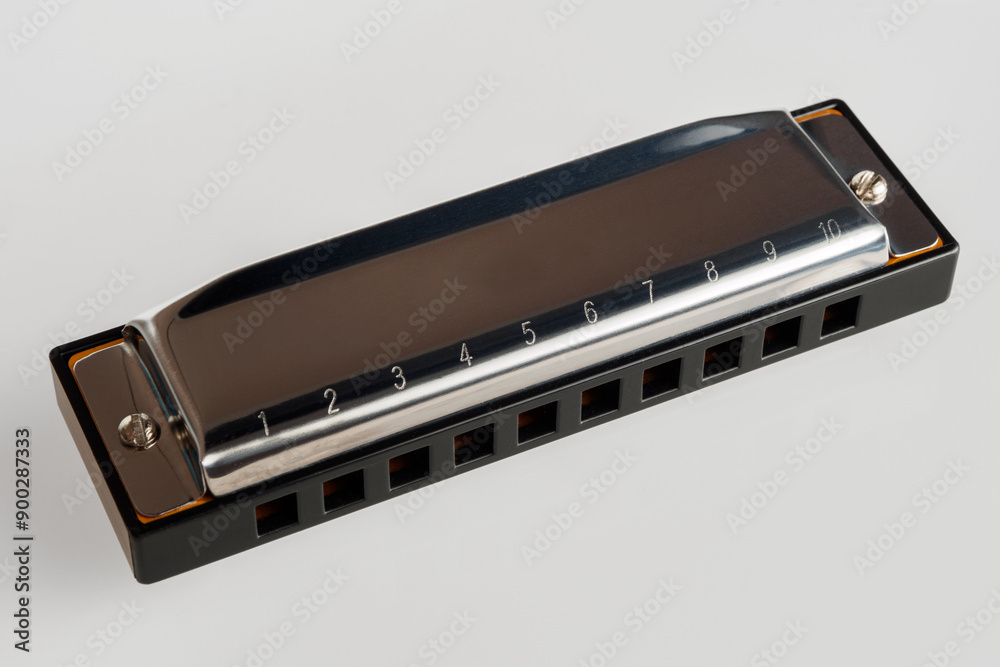Harmonica on a white background, a classic musical instrument ideal for jazz, blues and folk music Harmonica on a white background, a classic musical instrument ideal for jazz, blues and folk music