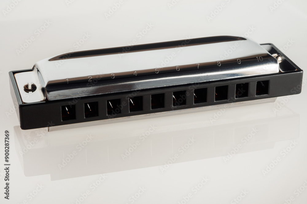 Harmonica on a white background, a classic musical instrument ideal for jazz, blues and folk music Harmonica on a white background, a classic musical instrument ideal for jazz, blues and folk music