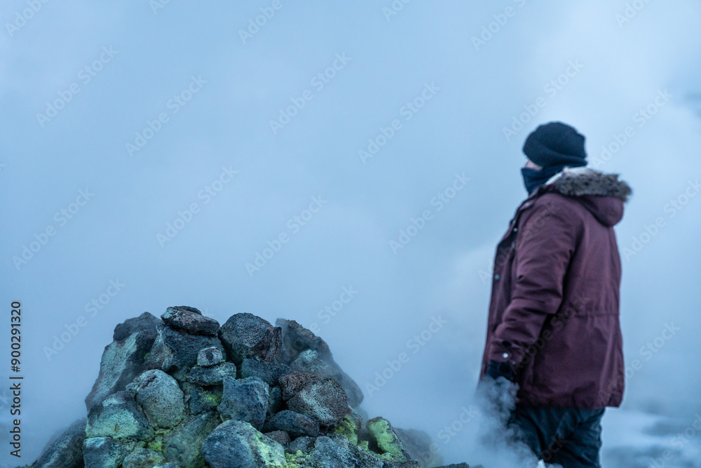 A man at the steaming fumaroles at Hverir or Namafjall geothermal park in winter, Iceland A man at the steaming fumaroles at Hverir or Namafjall geothermal park in winter, Iceland