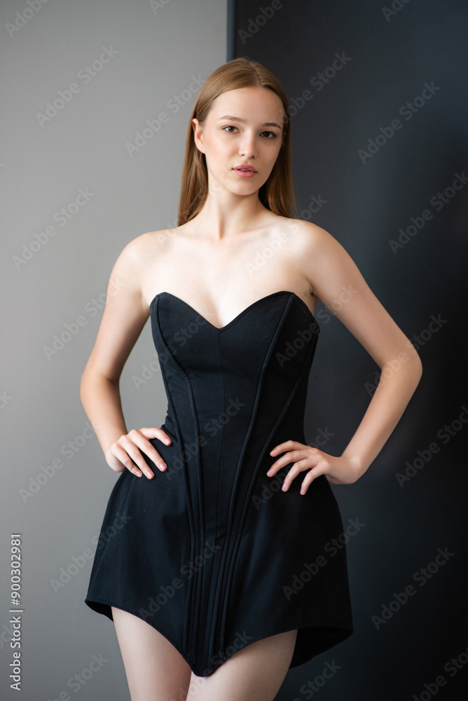 Fototapeta premium beautiful young woman wearing short black dress, studio shot.