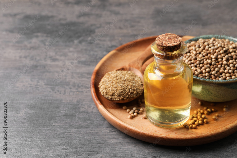 Coriander essential oil, seeds and powder on grey table, space for text Coriander essential oil, seeds and powder on grey table, space for text
