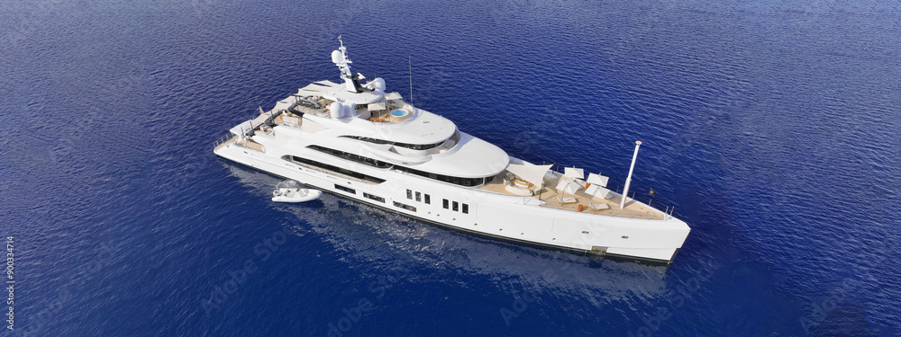 Aerial drone ultra wide top down photo with copy space of luxury yacht with wooden deck anchored in Aegean island with deep blue sea, Greece