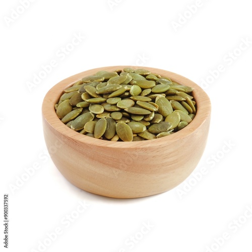 Pumpkin seeds in wooden bowls close up on white background.
