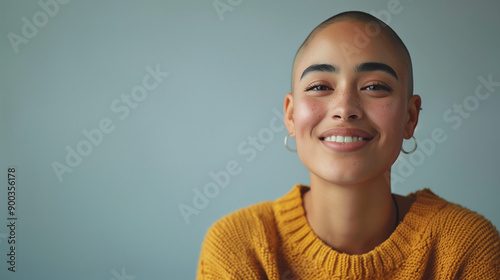 Professional portrait of a happy mixed race lesbian with buzzcut shaved head of hair. Gay black woman. Grey copy space for text	
 photo