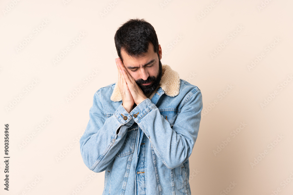 Caucasian man with beard over isolated background making sleep gesture in dorable expression Caucasian man with beard over isolated background making sleep gesture in dorable expression