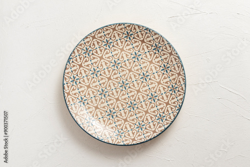 Empty porcelain plate with a pattern. On white background.