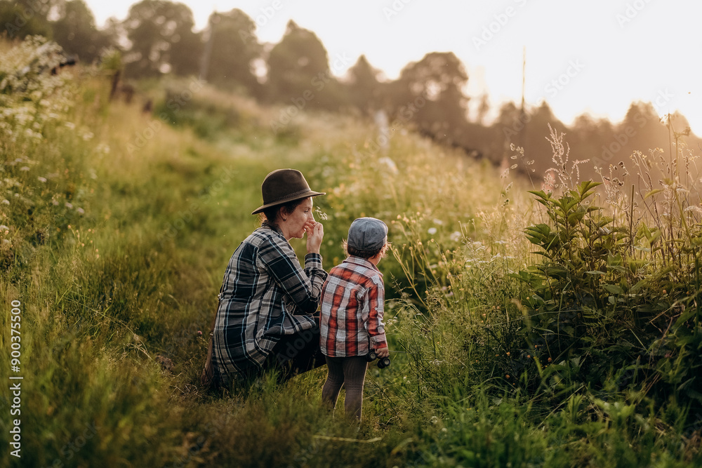 Summer trip with children to the mountains. Evening walk of a mother with a child in an alpine village in summer. Summer trip with children to the mountains. Evening walk of a mother with a child in an alpine village in summer.