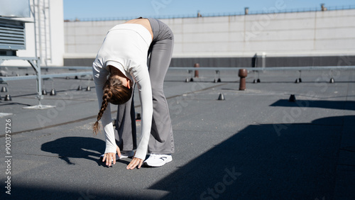 Fit woman exercise outdoors, stretching and doing jumps on the roof