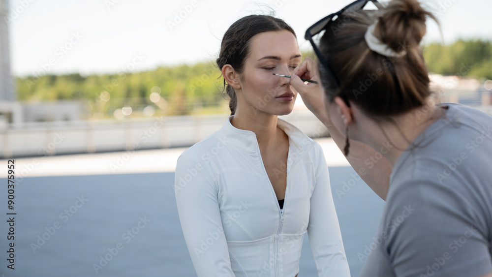 Professional makeup artist does mobile makeup for a young athletic girl Professional makeup artist does mobile makeup for a young athletic girl
