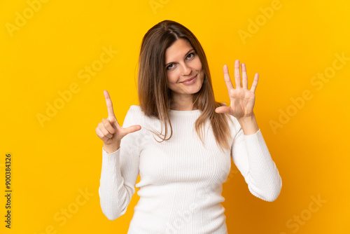 Young Slovak woman isolated on yellow background counting seven with fingers