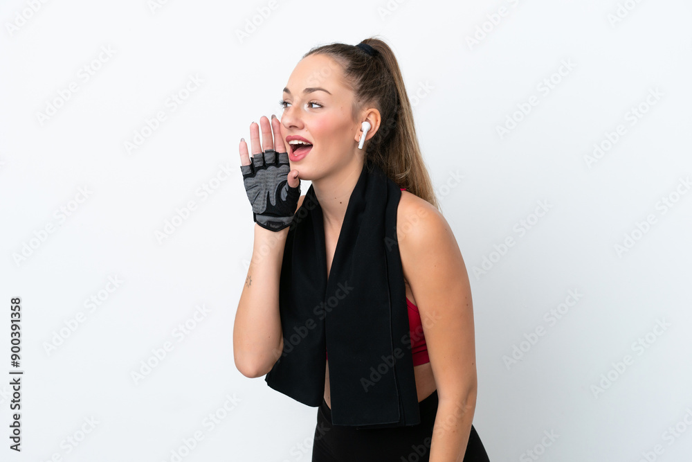 Young sport caucasian woman isolated on white background shouting with mouth wide open to the lateral Young sport caucasian woman isolated on white background shouting with mouth wide open to the lateral
