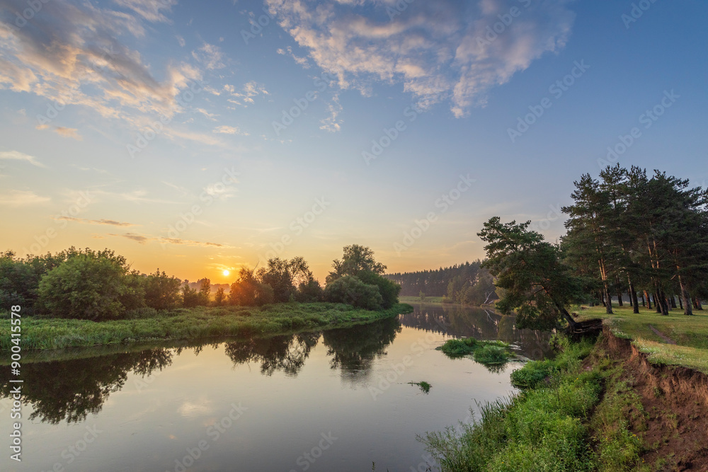 A beautiful sunset over a river with trees in the background A beautiful sunset over a river with trees in the background