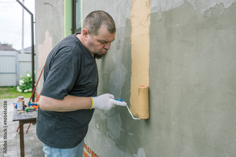 A man is painting a wall with a roller A man is painting a wall with a roller
