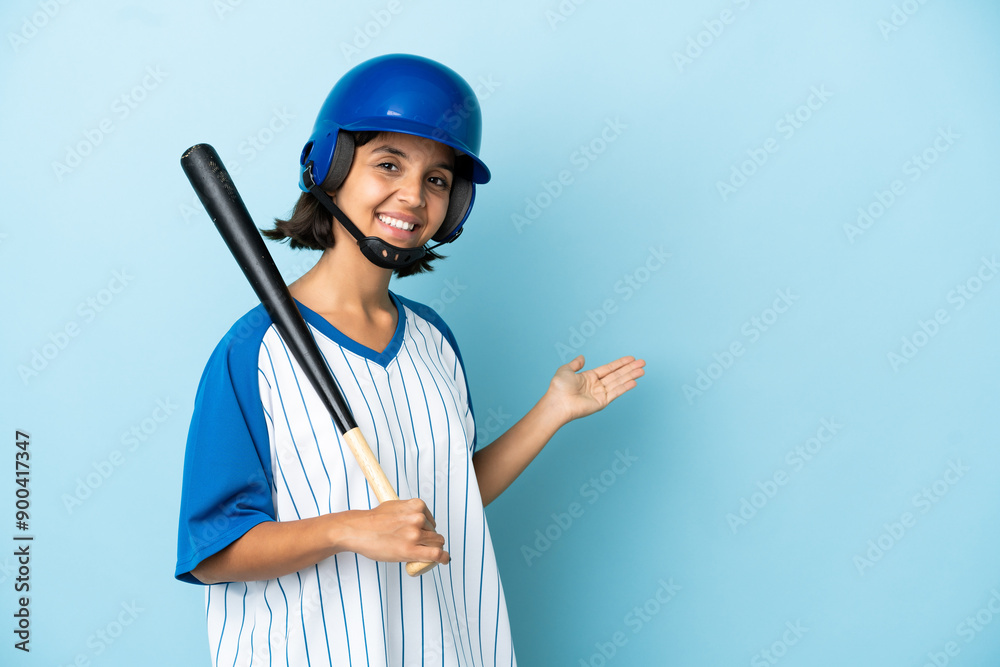 Baseball mixed race player woman with helmet and bat isolated on blue background extending hands to the side for inviting to come Baseball mixed race player woman with helmet and bat isolated on blue background extending hands to the side for inviting to come