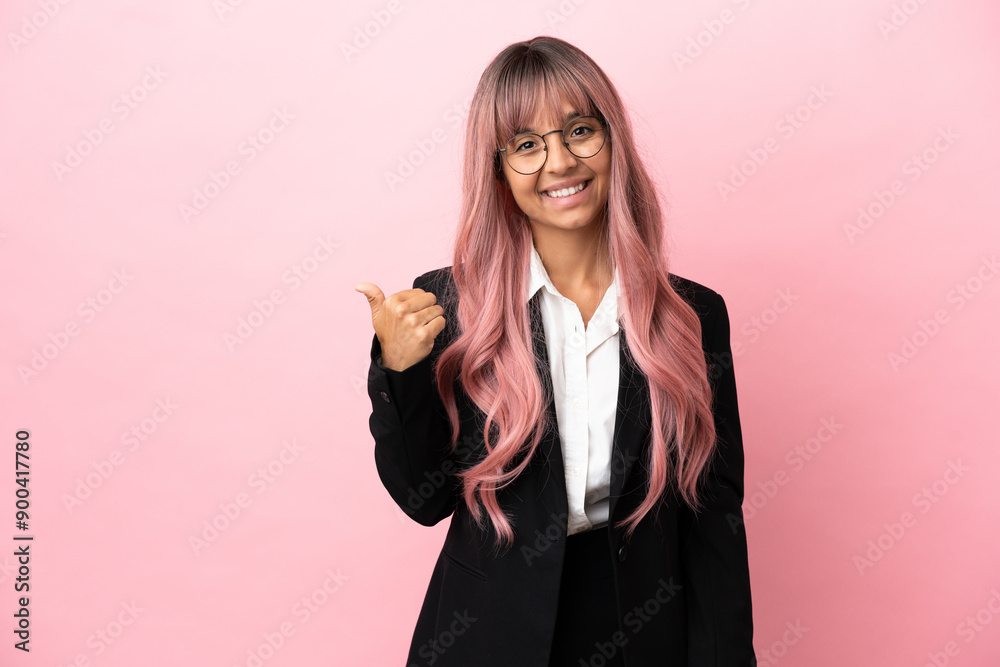 Young business mixed race woman with pink hair isolated on pink background pointing to the side to present a product Young business mixed race woman with pink hair isolated on pink background pointing to the side to present a product