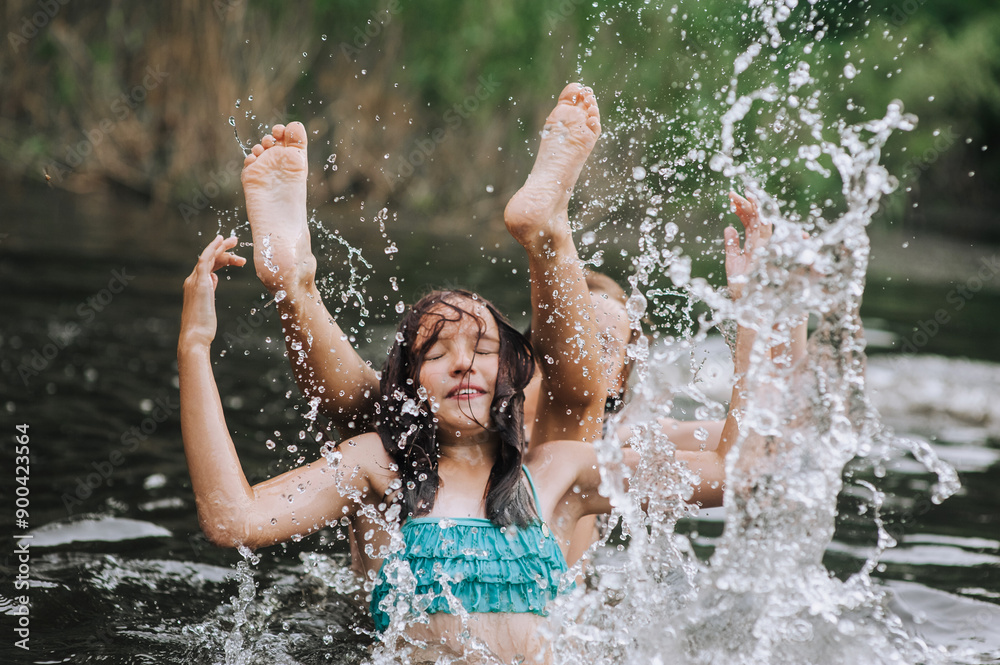 Fototapeta premium Two girlfriends, children in water playing, laughing, having fun in the lake in summer, swimming in the sea on vacation. Photography, portrait, childhood concept.