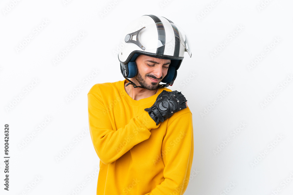 Young caucasian man with a motorcycle helmet isolated on white background suffering from pain in shoulder for having made an effort Young caucasian man with a motorcycle helmet isolated on white background suffering from pain in shoulder for having made an effort