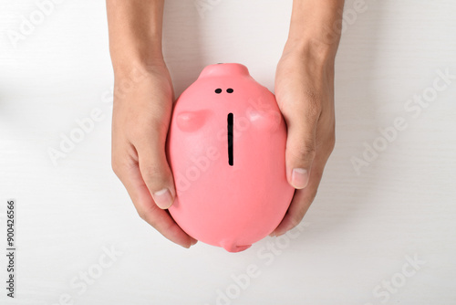 Man hand holding piggy bank for saving money isolated on white background. Saving money for retirement fund and future plan concept. Saving cost increase more income concept