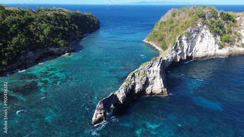 The image showcases a stunning coastal landscape with a turquoise sea, rocky cliffs, and lush greenery. It captures the beauty of nature and the serenity of the ocean.