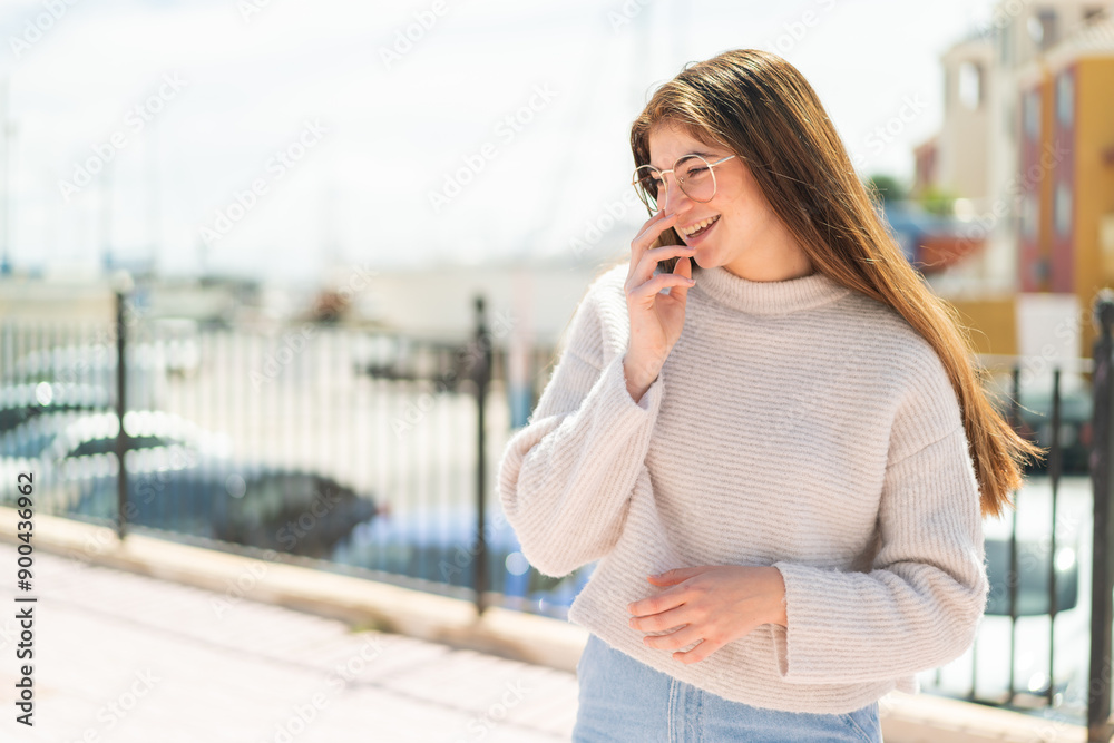 Fototapeta premium Young pretty caucasian woman with glasses at outdoors smiling a lot