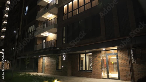 modern entrance of a multi-storey building, night illumination of the yard