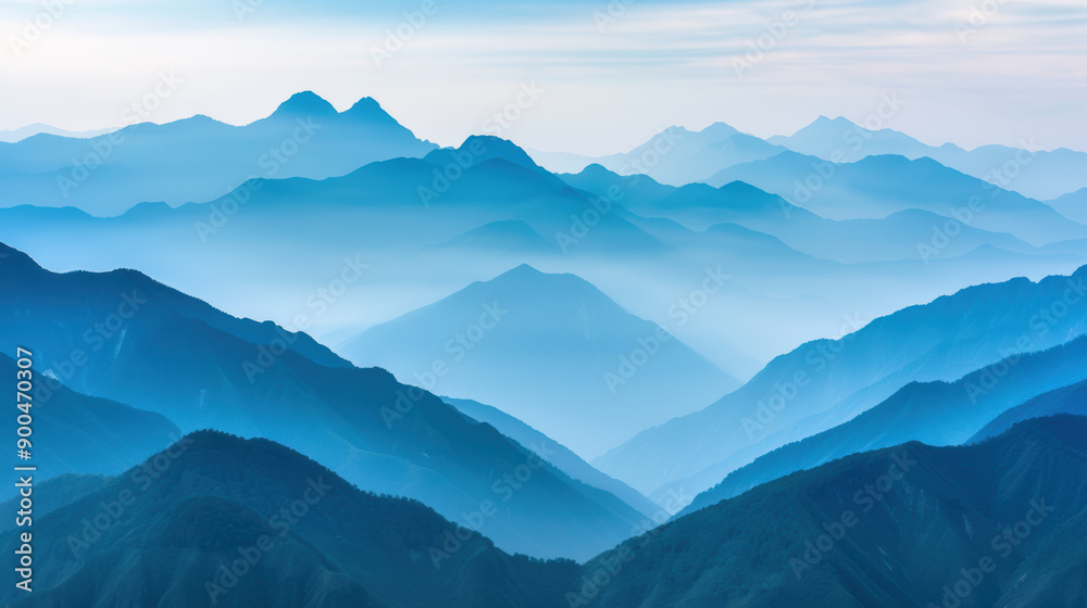 Obraz premium A breathtaking view of misty blue mountains with serene skies. Layered mountain ranges create a sense of depth and tranquility. Ideal for nature lovers.