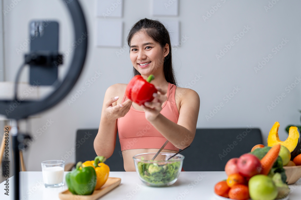 Influencer woman holding red pepper recording cooking show video using smartphone Influencer woman holding red pepper recording cooking show video using smartphone