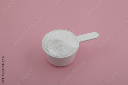 Sodium percarbonate powder or sodium carbonate peroxide in measuring scoop. It is abbreviated as SPC. White chemical compound. Chemical substance used in eco-friendly bleaches with active oxygen. photo