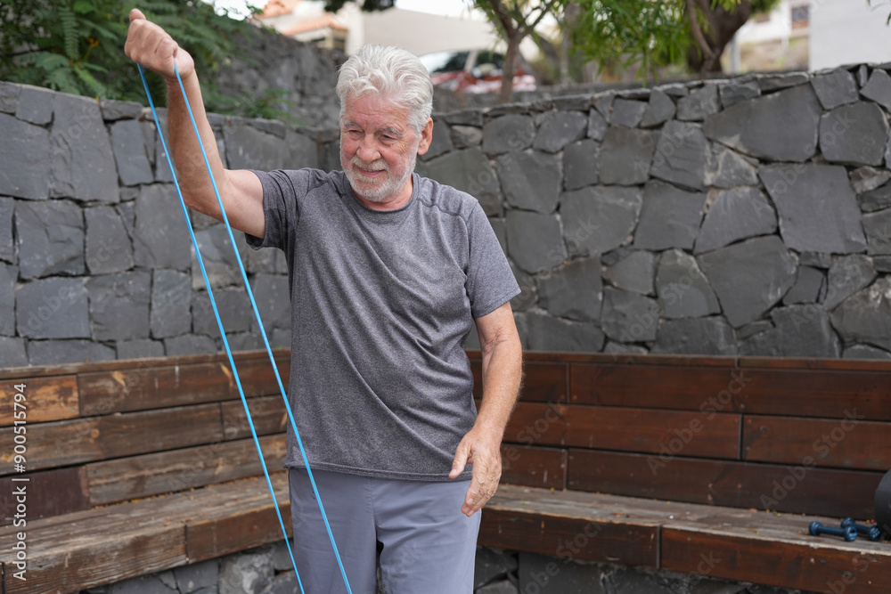 Senior man exercises with a resistance band in an outdoor setting, promoting fitness and healthy living for elderly individuals Senior man exercises with a resistance band in an outdoor setting, promoting fitness and healthy living for elderly individuals