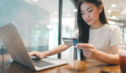 Woman hand consumer using creadit card and laptop on wooden table