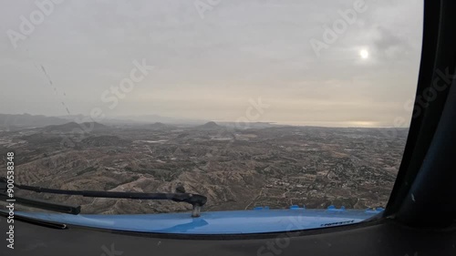 The plane flies over a mountainous desert area. Cockpit view.